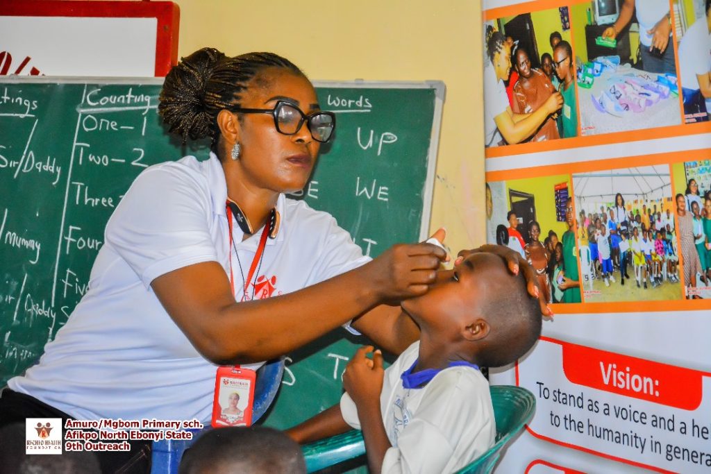 Our Chairperson in action putting an eye drop on one of the pupils.